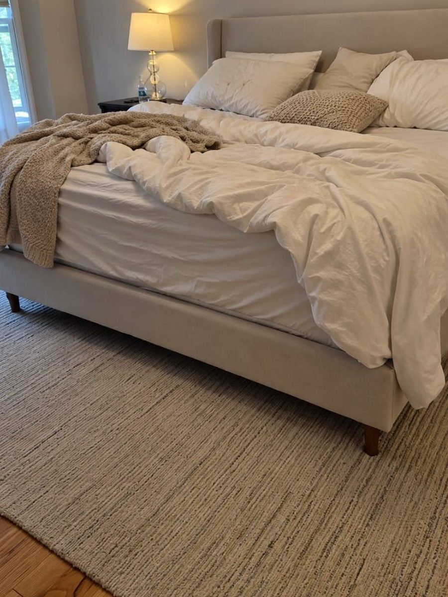 Bedroom before service, with the duvet pulled back, bedding bunched at the foot of the bed and a throw draped over the corner
